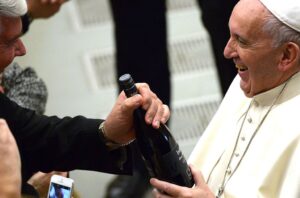 Papa Francisc primind o sticla de vin