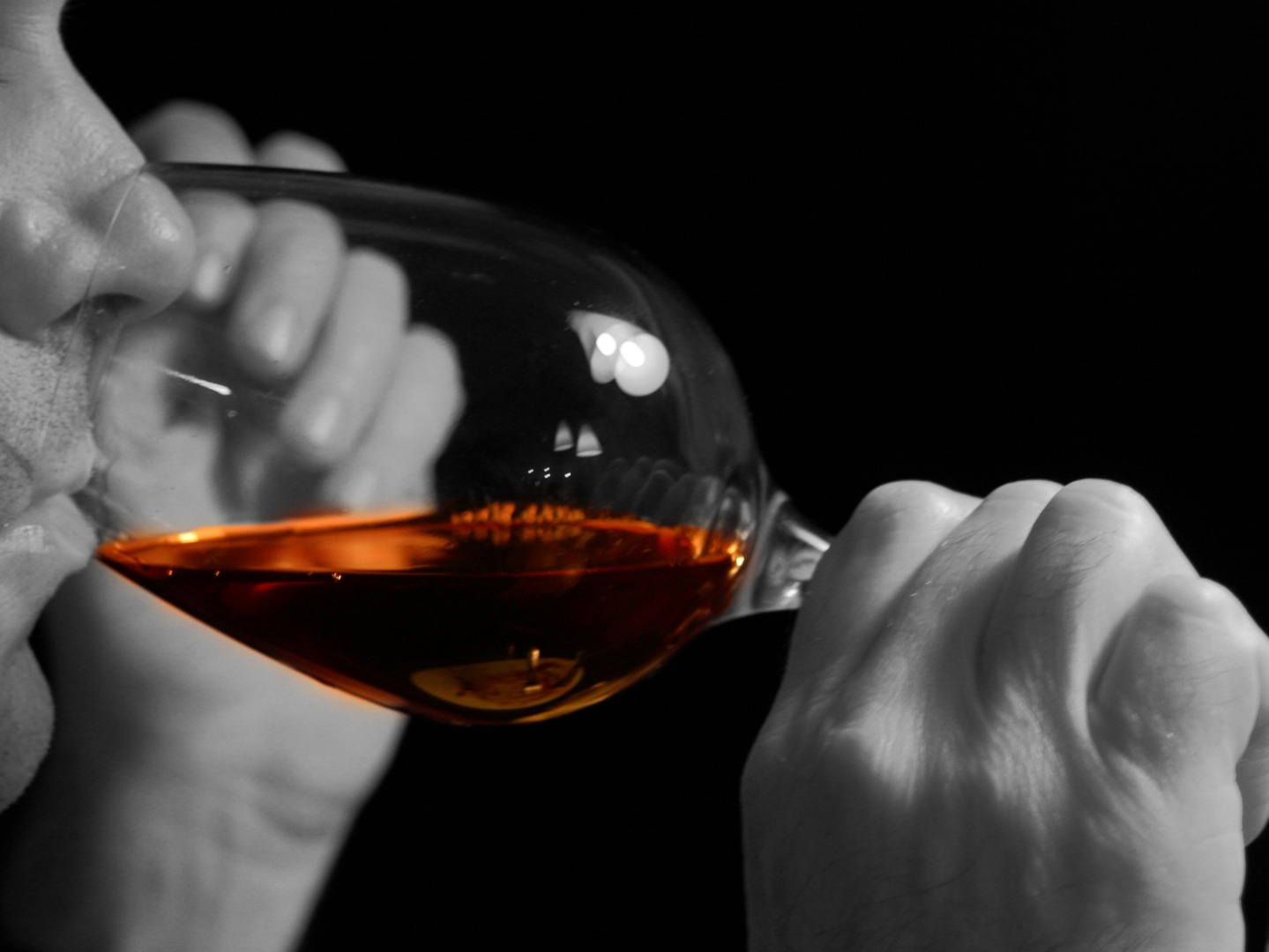 Un bărbat bea un pahar de vin