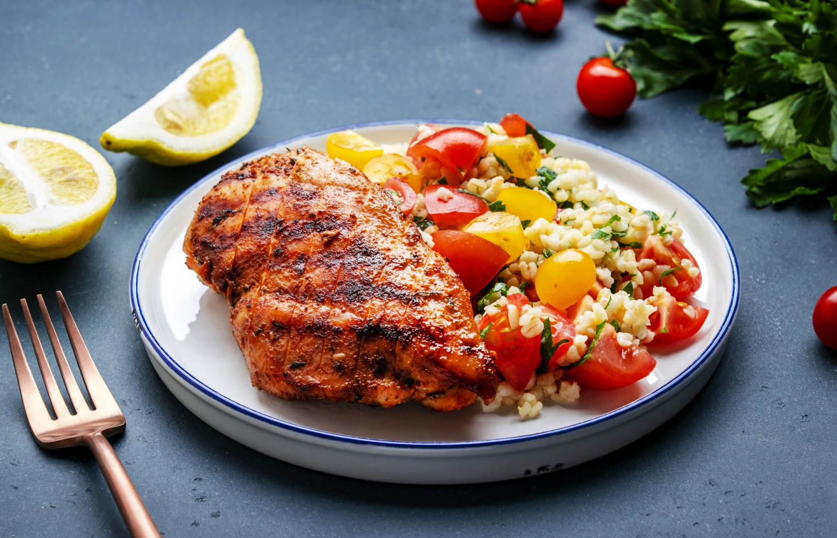 Farfurie pe care se află o portie de tabbouleh ți un piept de curcan la grătar