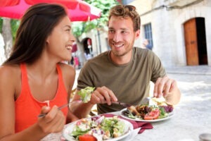 Cuplu care mananca carne sau peste, la restaurant