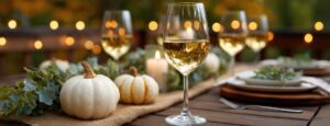Masă decorată de toamnă, un pahar de vin, dovleci